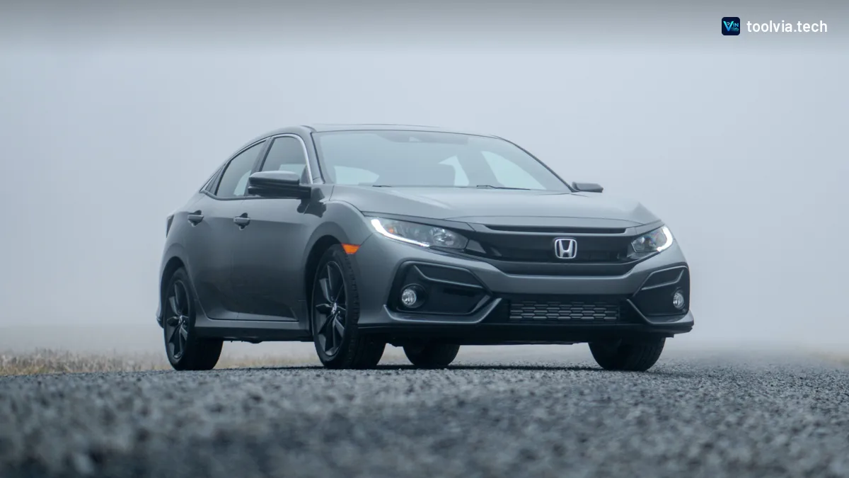 Grey Honda Civic hatchback on a gravel road in fog
